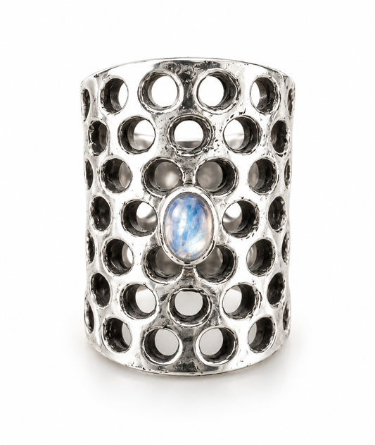 Arista sterling silver ring with a wide perforated band and an oval rainbow moonstone displaying a blue flash.